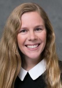 Brandy Henry headshot with long blonde hair and black shirt with white collar.