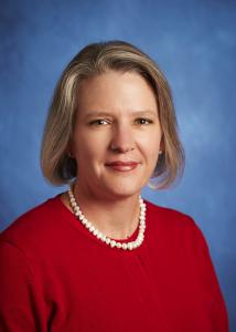 Headshot of Karen Murphy with short light brown hair, pearl necklace, and red blouse.