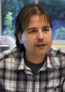 Idan Shalev in black and white plaid flannel shirt.