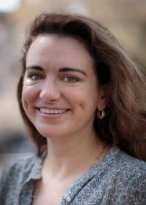 Sarah Brothers headshot with long brown hair, gray blouse