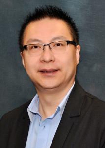 Headshot of Bing Ran, an Assian man with short hair, glasses, a black jacket, and blue shirt.
