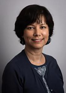 Headshot of Rina with short dark brown hair and dark blue sweater.
